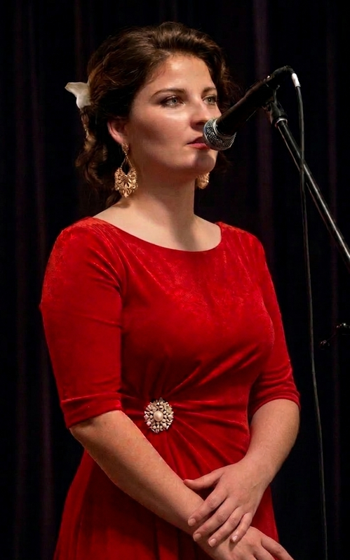Tess Hopewood, vocal coach and director, singing into a microphone